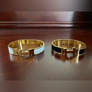 2 H buckle bracelets. One white. One black